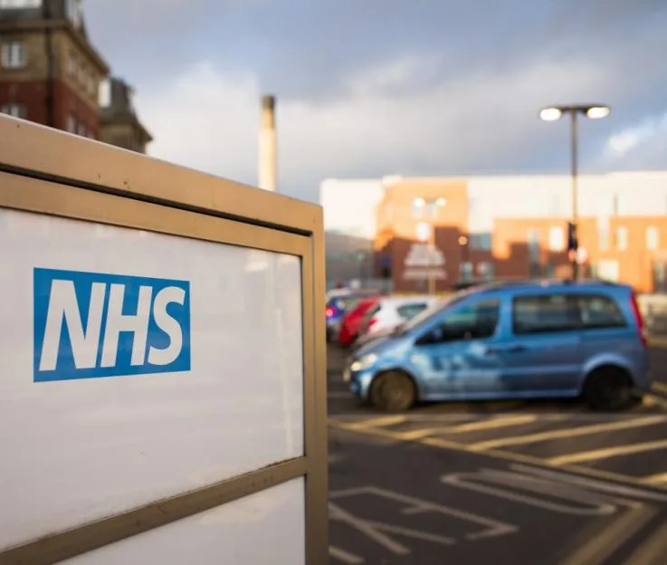 NHS logo on an entrance sign for the Royal Victoria Infirmary.