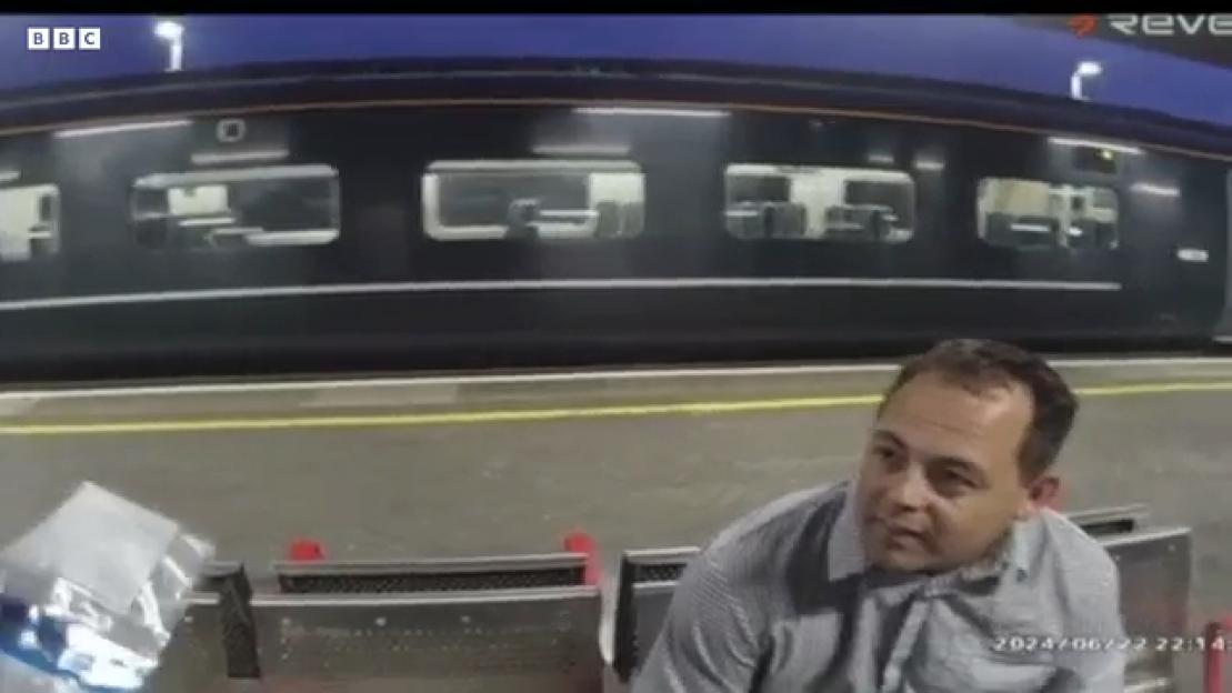 Nicholas McMurray, a train inspector, sitting on a bench at a train station.