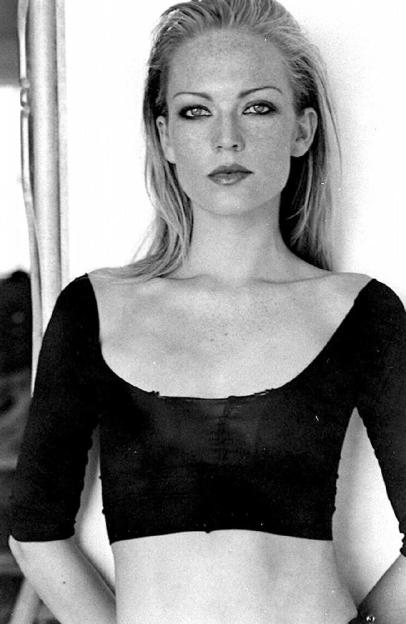 a black and white photo of a woman in a crop top