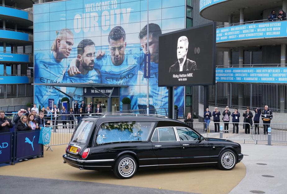Ricky Hatton's hearse arriving at the Etihad Stadium with a large screen displaying his image and dates of birth and death, as people line up to pay their respects.