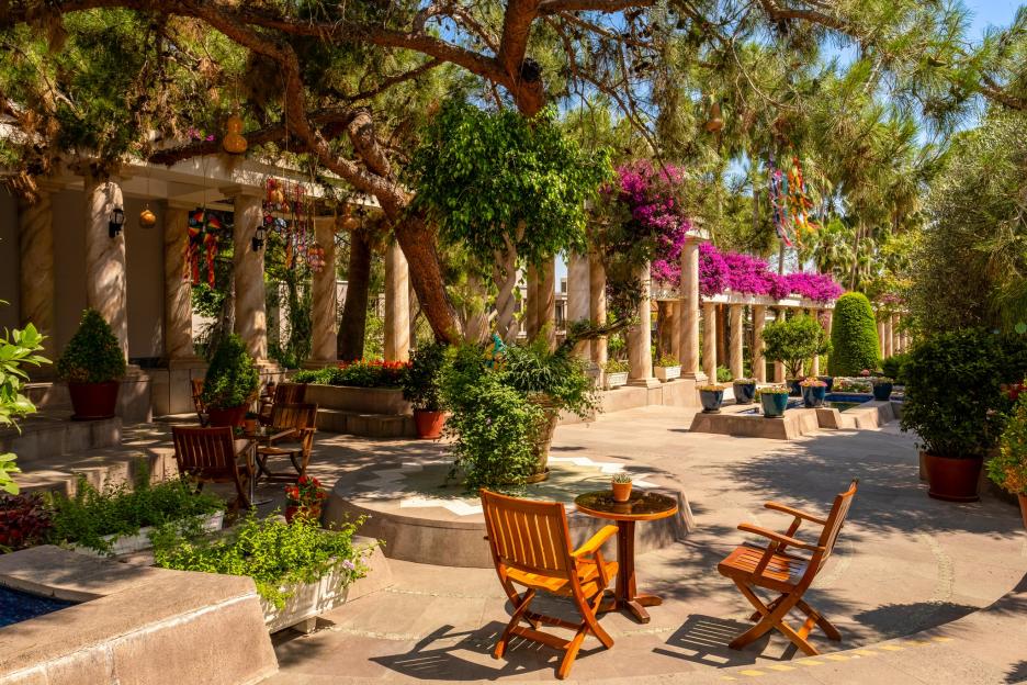 Courtyard at Tui Magic Life resort in Belek, Turkey, with chairs and tables under trees and bougainvillea.