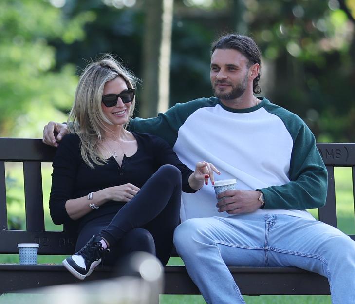 Holly Valance and Grant Gale sitting on a park bench.