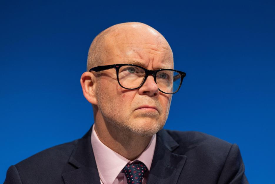 Lord Toby Young, founder of the Free Speech Union, peaking from a stage.