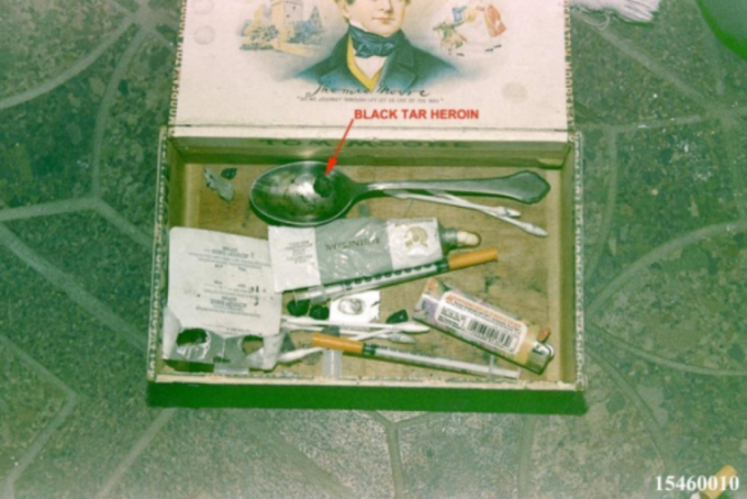 An open box, illustrated with a man in 1800s attire, contains drug paraphernalia including a spoon with "BLACK TAR HEROIN" indicated by a red arrow, syringes, a tube, a lighter, and cotton swabs.