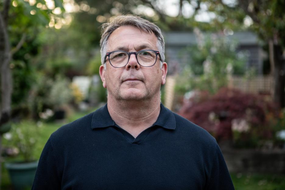 Simon Stanley in a dark collared shirt and glasses.