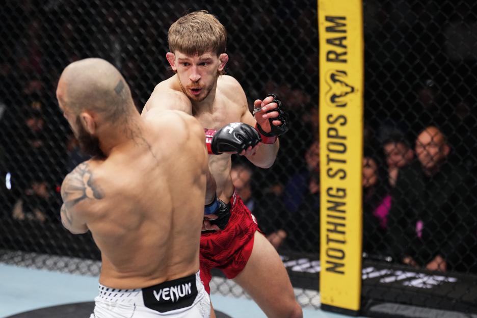 Arnold Allen of England strikes Jean Silva of Brazil in a featherweight bout during the UFC 324 event.