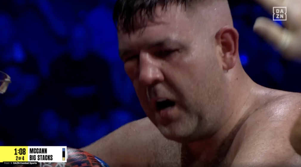 Boxer McCann looking down, sweaty, with a swollen left eye.