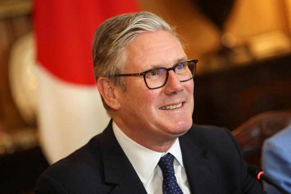 Britain's Prime Minister Keir Starmer smiles during a business roundtable meeting.