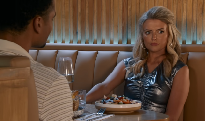 Bethany Platt in a metallic silver dress seated at a restaurant table.