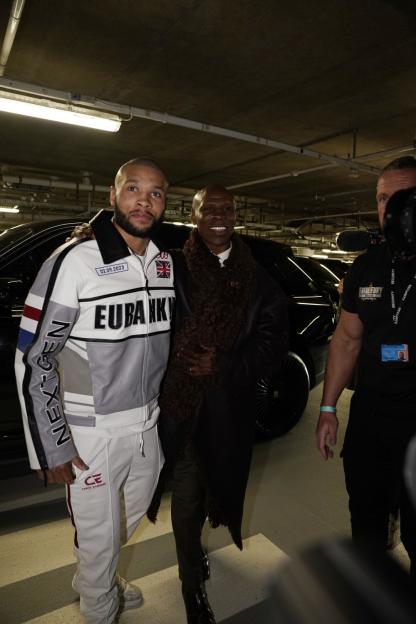 Chris Eubank Jr. and Chris Eubank Sr. smiling and posing in a parking garage.