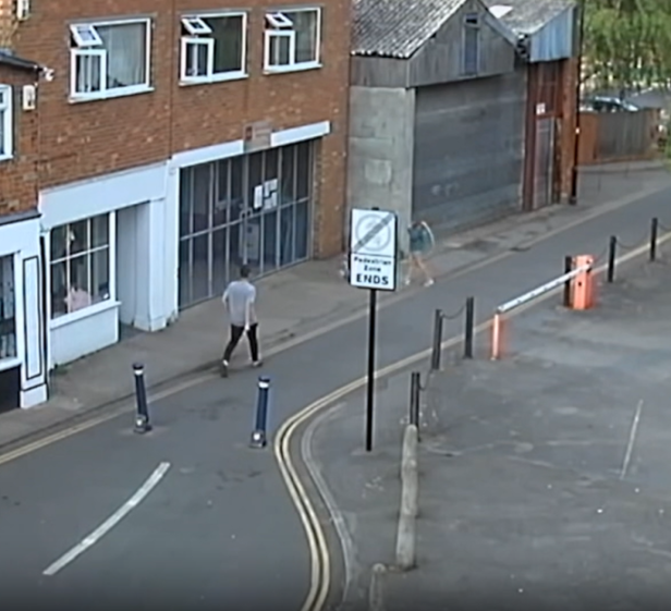 A man walking on a street as a person in a skirt moves towards a pedestrian zone.