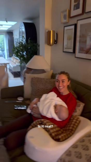 Sophie Habboo holding her baby son Ziggy, sitting on a couch.