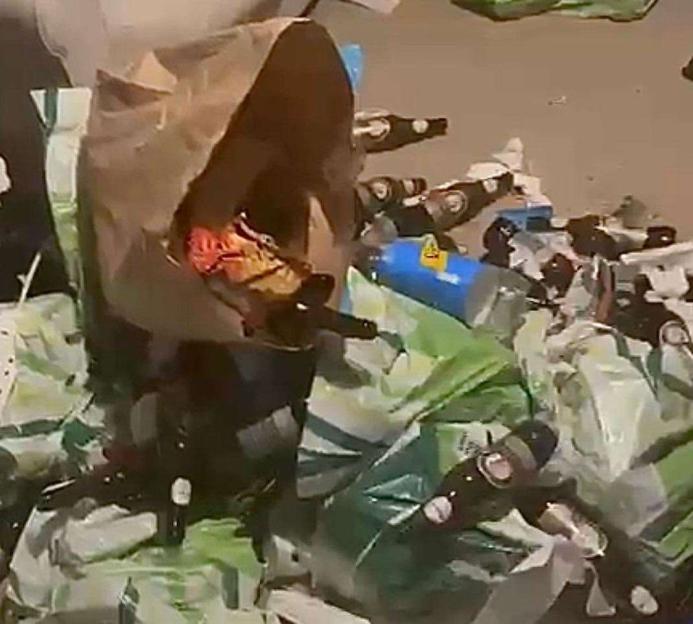 An Uber Eats bag surrounded by empty bottles and rubbish.