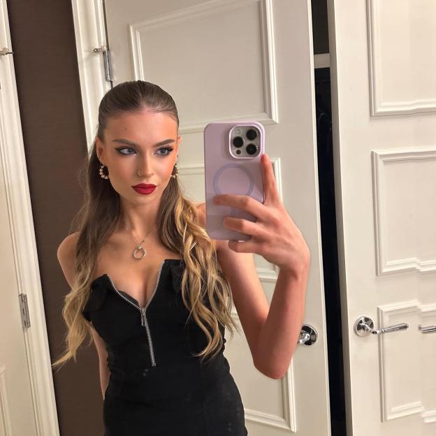 Isabelle Sapherson-Moralee taking a selfie in a black zippered dress.