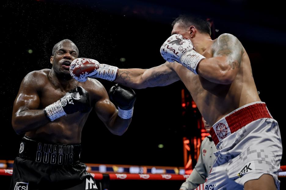 Oleksandr Usyk (right) punches Daniel Dubois (left) during a boxing match.