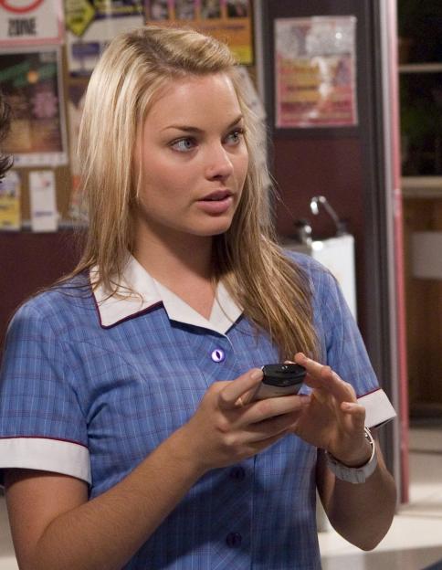 Three actors, one with crutches, standing in a hallway.