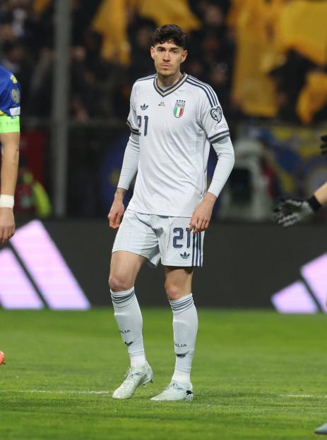 An Italian football player in a white uniform with number 21 on the field.