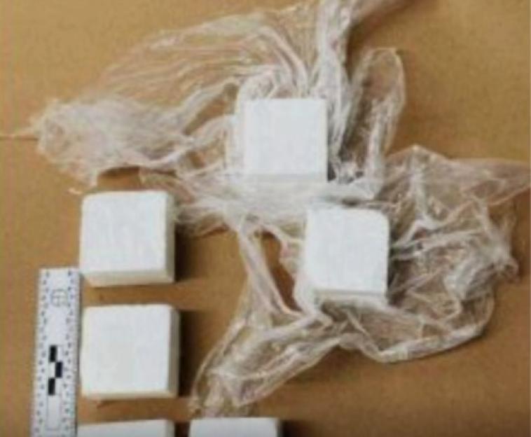 Seized drugs, possibly cocaine, in block form.