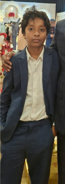 Portrait of Yafee, a missing boy with dark skin, dark hair, and brown eyes, wearing a white shirt and a dark blue suit.