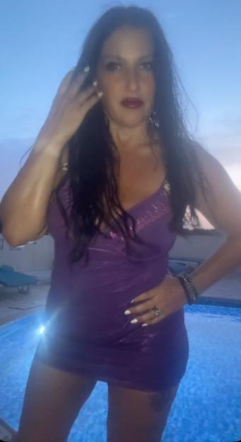 Amanda Moss in a purple dress next to a pool.