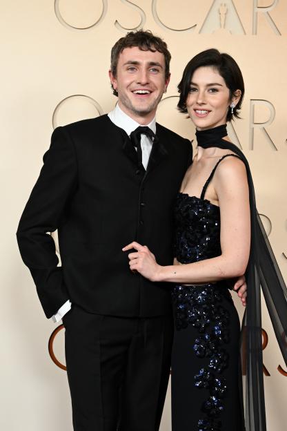 Paul Mescal in a black suit with a bow tie and Gracie Abrams in a black sequin dress with a sheer cape at the 98th Annual Academy Awards.