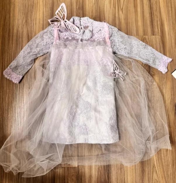 Light purple and white lace dress with sheer sleeves and a full skirt, adorned with two butterfly cutouts.