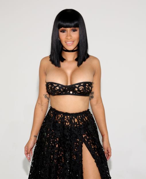 Cardi B in a black lace bralette and matching skirt with a thigh-high slit.