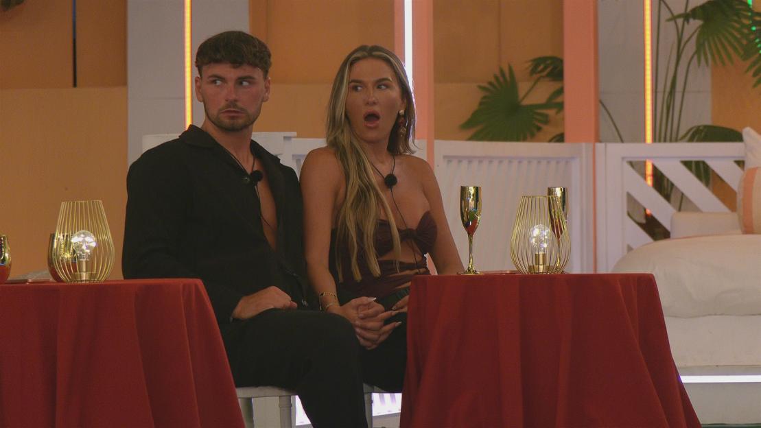 Ty and Angel from Love Island sitting at a table with drinks and lanterns.