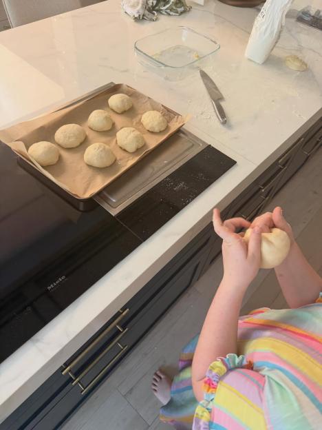 A person kneading dough in a kitchen.