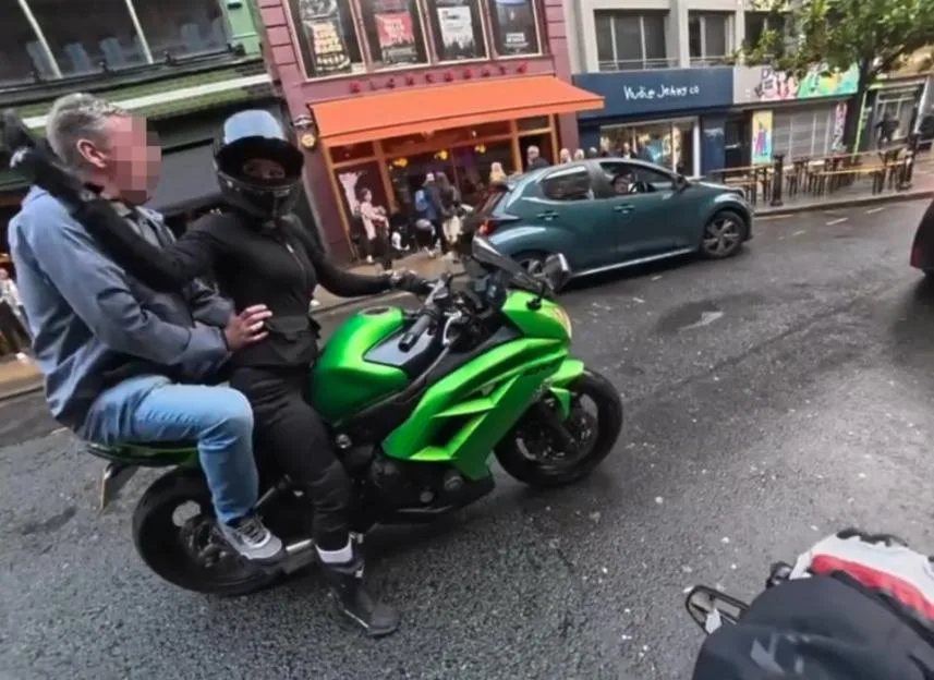VIDEO: Motorcycle rider smacks 'inappropriate' old man jumping onto bike and grabbing her hips while she's sitting in traffic