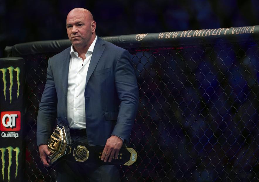 UFC President Dana White holding a UFC lightweight championship belt.