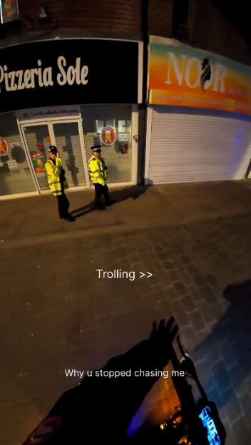 A first-person perspective at night showing two police officers in front of a store with text overlays "Trolling >>" and "Why u stopped chasing me".