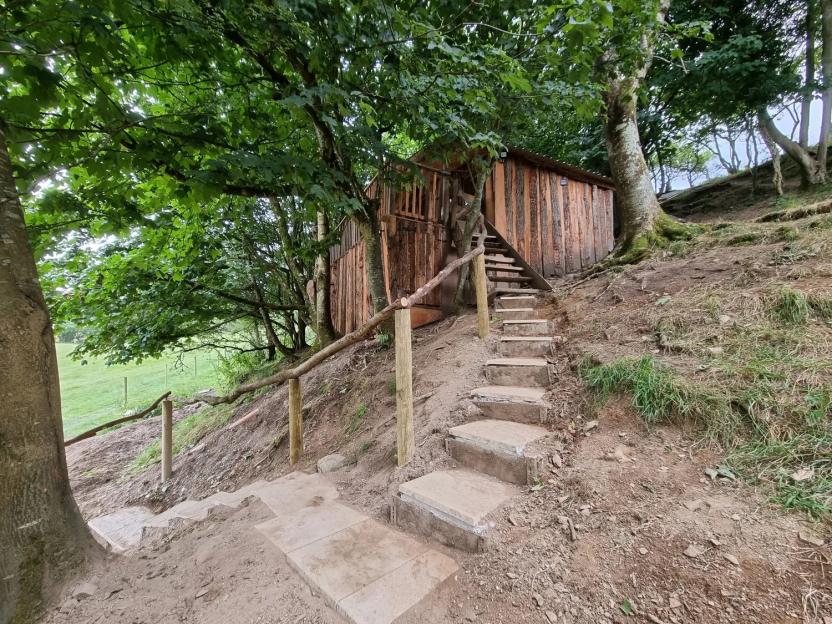 Tree House in Oakford near Aberaeron, Ceredigion, with steps leading up to it.