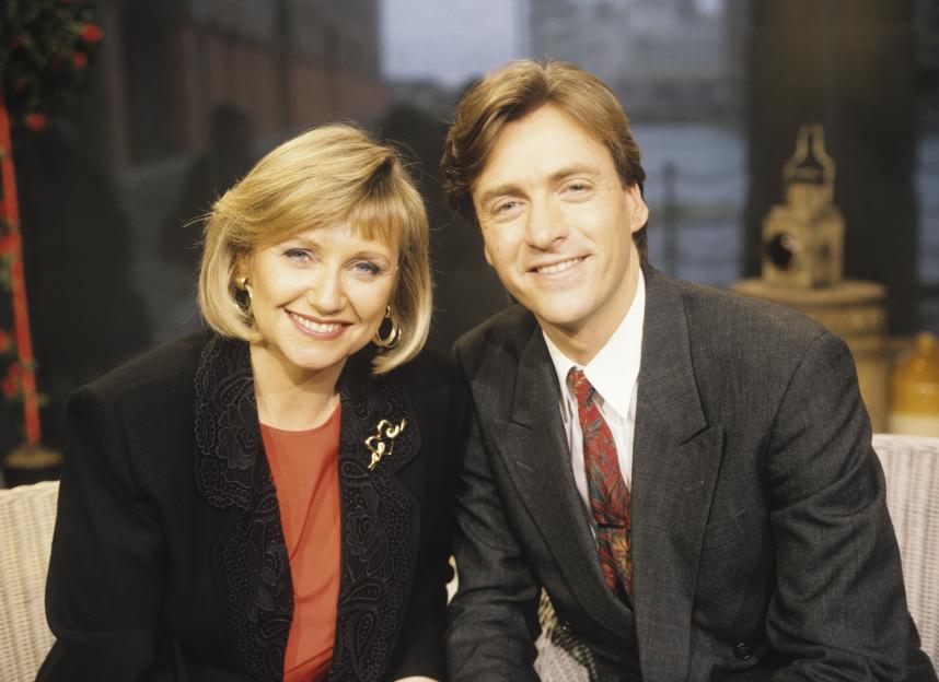Married presenters Judy Finnigan and Richard Madeley smile at the camera.