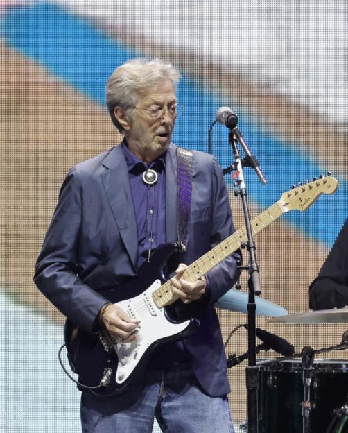 Eric Clapton playing a dark blue electric guitar at the Crossroads Guitar Festival.