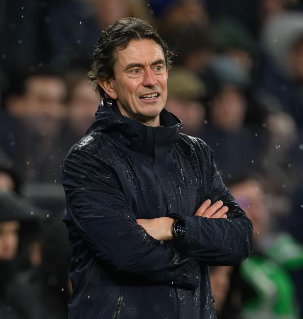 Tottenham Manager Thomas Frank, dressed in a black rain jacket, arms crossed.