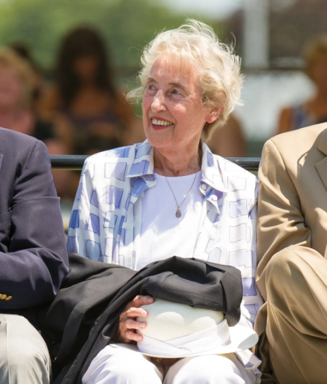 Woman smiling and looking to her left.