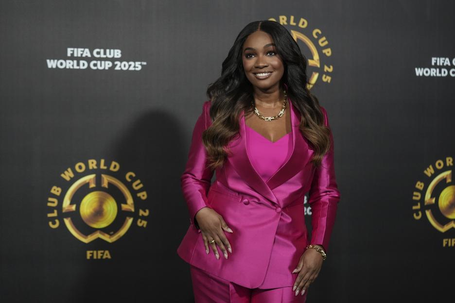 Presenter Samantha Johnson wearing a fuchsia suit, standing in front of a black background with "FIFA CLUB WORLD CUP 2025" and logos.
