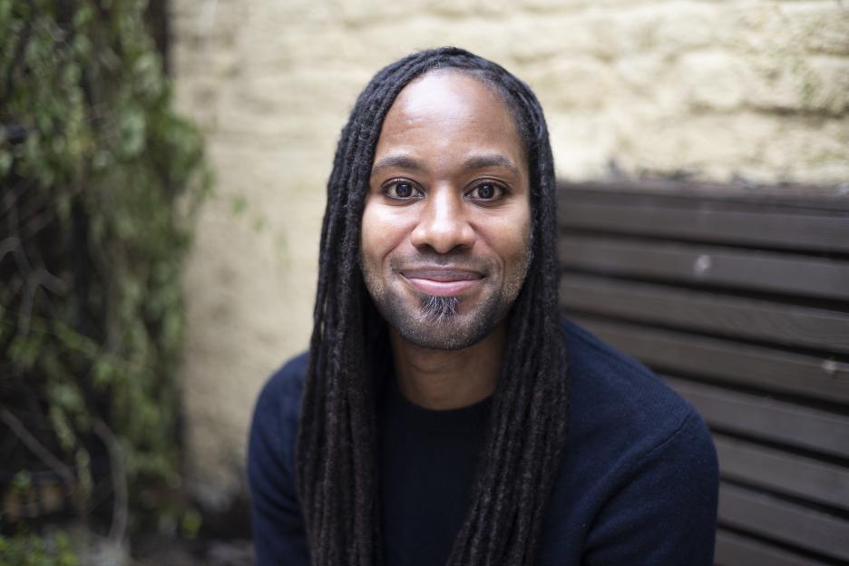 Jason Arday, the youngest Black professor at Cambridge University, looks at the viewer and smiles.