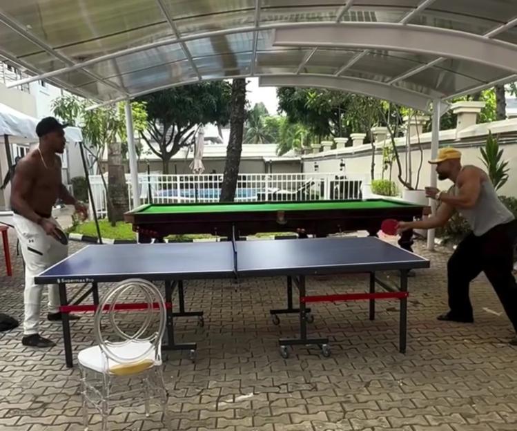 Anthony Joshua and Kevin Ayodele playing table tennis.