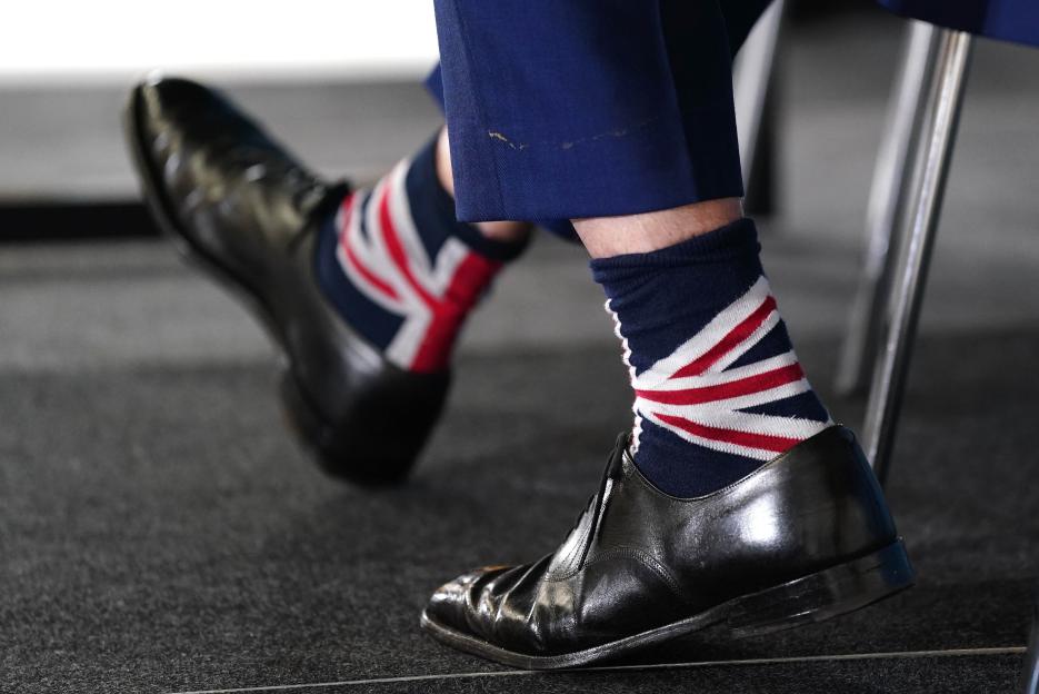 Nigel Farage's feet in black shoes and Union Jack socks.