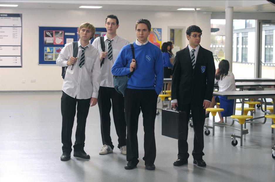 Four young men in school uniforms from "The Inbetweeners Movie" standing in a cafeteria.