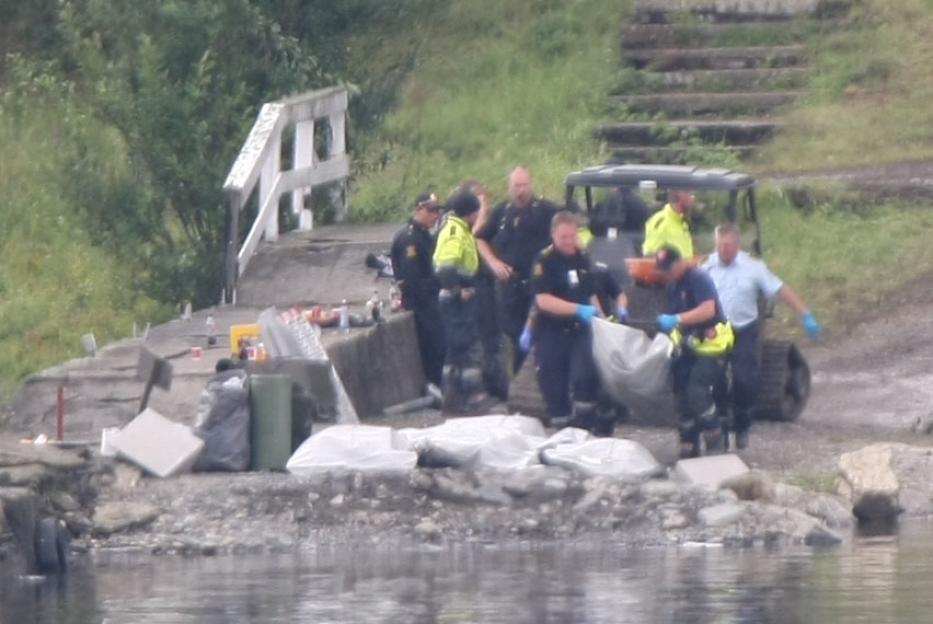 Police remove bodies ( in white body bags ) from Utoya Island, near Oslo.