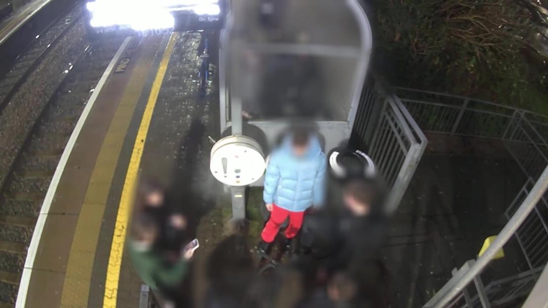 Video still showing police arresting a teen suspect on a train platform.