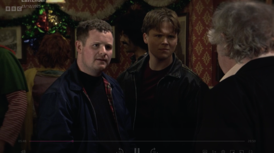 Three men, two facing forward and one with his back to the camera.