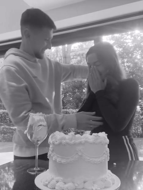 Emotional couple embracing with a cake in front