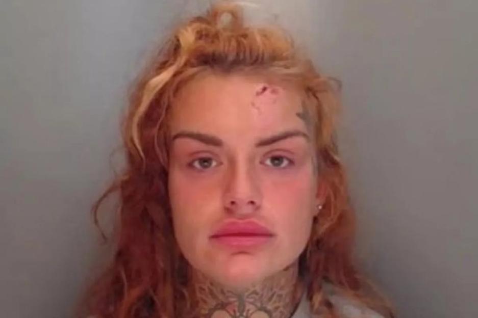 Mugshot of Kelsey Bainbridge with a visible wound on her forehead and tattoos on her neck.