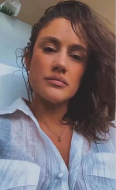 Katie Waissel wearing a white shirt and a necklace.