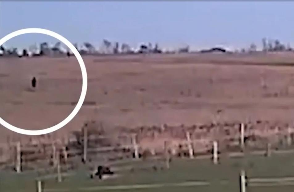 An image collage containing 1 images, Image 1 shows CCTV footage of a person in the distance walking across an empty field