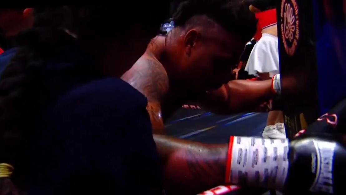 Boxer leaning against the corner of the ring after collapsing.